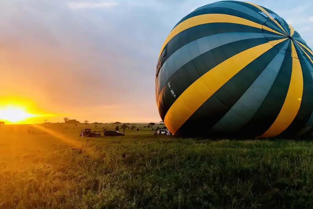 A hot air balloon being inflated at sunrise in the Serengeti
