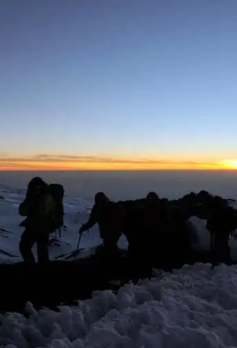 Climbers silhouetted against the dawn sky on Kilimanjaro